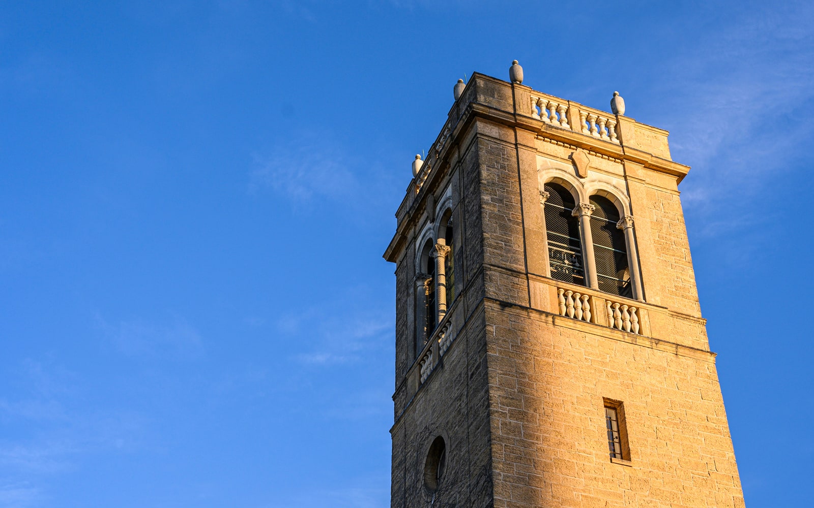 The top of the Carillon Tower at UW–Madison against a blue sky.